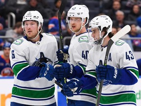 Vancouver Canucks center Elias Pettersson (40) celebrates his goal right wing Brock Boeser (6) and defenseman Quinn Hughes (43) during the third period at UBS Arena Feb. 9, 2023. Dennis Schneidler-USA TODAY Sports