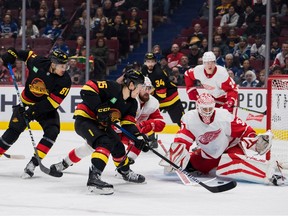 Vancouver Canucks forward Dakota Joshua (81) and forward Sheldon Dries (15) look for the rebound while Detroit Red Wings goalie Ville Husso (35) makes a first-half block at Rogers Arena.