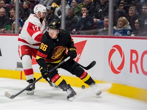 Detroit Red Wings defenseman Filip Hronek (17) checks Vancouver Canucks forward Andrei Kuzmenko (96) in the first half at Rogers Arena.