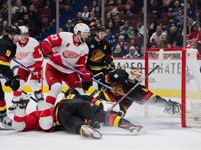 Vancouver Canucks forward JT Miller (9) and defenseman Quinn Hughes (43) and Detroit Red Wings forward Michael Rasmussen (27) watch as forward Robby Fabbri (14) scores against goaltender Collin Delia (60) in the second period at Rogers Arena .