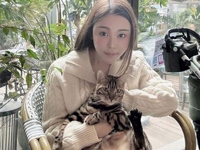 In this photo taken and provided by Pao Jo-yee, model Abby Choi, holding a cat, poses for a photo on Feb. 11, 2023, in Hong Kong. The ex-husband and former in-laws of the slain Hong Kong model were put in custody without bail Monday, Feb. 27, 2023, on a joint murder charge, after police found parts of her body in a refrigerator.