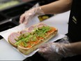 In this April 7, 2013 file photo, an employee prepares a sandwich inside a Subway fast food restaurant in Moscow, Russia.
