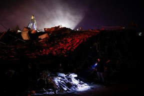 A man uses a flashlight to check damaged buildings, in the aftermath of an earthquake, in Antakya, Turkey, Feb. 8, 2023.