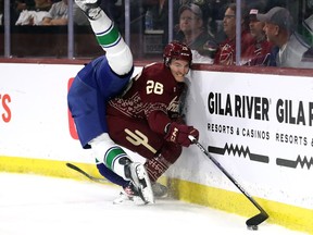 Laurent Dauphin of the Arizona Coyotes avoids a hit from Tyler Myers of the Vancouver Canucks during the first period at Mullett Arena on Thursday night.