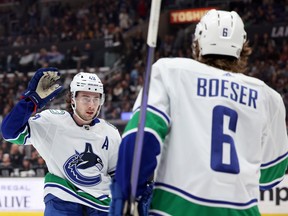 Brock Boeser of the Vancouver Canucks celebrates his goal with Quinn Hughes to take a 1-0 lead, during the first period at Crypto.com Arena on March 18, 2023 in Los Angeles.