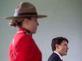 An RCMP officer stands by as Prime Minister Justin Trudeau addresses new Canadians during a citizenship ceremony in Kelowna, B.C., Wednesday, Sept. 6, 2017. Trudeau says having an Indigenous person serve as the next RCMP commissioner is "an excellent idea."