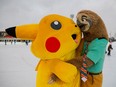 People dressed in costumes of Pokemon's Pikachu and Zootopia's sloth hug each other during a carnival devoted to St. Valentine's Day in Moscow, February 14, 2021.