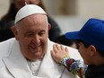 A boy pats Pope Francis on the shoulder while leaving in the popemobile on Wednesday, March 29, 2023 at the end of the weekly general audience at St. Peter's square in The Vatican.