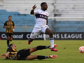 Vancouver Whitecap Cristian Dajome leaps over the sprawling Devron Garcia of Real CD Espana during the second leg of their CONCACAF Champions League two-match series at the Olimpico Metropolitano stadium in San Pedro Sula, Honduras, on Wednesday.