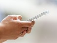 A person uses a cellphone in Ottawa, July 18, 2022. Some Canadians will pay more to use their cellphone data or place calls and text messages when travelling internationally beginning next week.