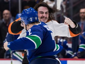 Philadelphia Flyers winger Zack MacEwen tangles with Canucks defenceman Luke Schenn (in blue) during an Oct. 28, 2021 NHL game at Rogers Arena.