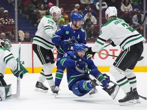 Dallas Stars’ Jani Hakanpaa (2) checks Vancouver Canucks’ Anthony Beauvillier (72) and receives an interference penalty as Vancouver’s Elias Pettersson (40) and Dallas’ Esa Lindell (23) look on during the first period at Rogers Arena on Tuesday.