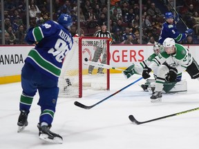 Vancouver Canucks’ Andrei Kuzmenko (96) scores against Dallas Stars goalie Matt Murray (32) as Esa Lindell (23) defends while Ryan Suter (20) and Vancouver’s J.T. Miller (9) watch during the first period at Rogers Arena on Tuesday.