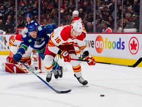 Vancouver Canucks forward Sheldon Dries (15) battles with Calgary Flames defenseman Nikita Zadorov (16) in the first period at Rogers Arena.