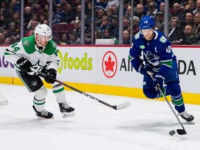 Dallas Stars defenceman Joel Hanley (44) defends against Vancouver Canucks forward Elias Pettersson (40) in the first period at Rogers Arena.