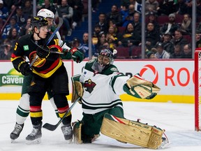 Minnesota Wild goalie Marc-Andre Fleury  makes a save as Vancouver Canucks forward Sheldon Dries  battles with defenceman Matt Dumba  in the first period at Rogers Arena March 2, 2023.