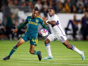 L.A. Galaxy forward Raheem Edwards, left, and Vancouver Whitecaps forward Cristian Dajome vie for the ball during the first half of an MLS match in Carson, Calif., Saturday.