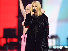 Avril Lavigne presents as a topless protester rushes the stage during the Junos Monday, March 13, 2023. Police say charges are pending after a topless protester interrupted the Juno Awards.