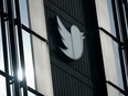 FILE - A Twitter logo hangs outside the company's offices in San Francisco, on Dec. 19, 2022. William Shatner, Monica Lewinsky and other prolific Twitter commentators -- some household names, others little-known journalists -- could soon be losing the blue check marks that helped verify their identity on the social media platform.