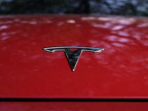 FILE - A Tesla logo is seen on a vehicle on display in Austin, Texas, Wednesday, Feb. 22, 2023. On Wednesday, March 1, Tesla executives said the company will use innovative manufacturing techniques and smaller factories to cut the cost of its next generation of vehicles by as much as half of the ones it now builds.