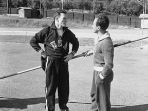 FILE - American pole vaulter Bob Richards, left, talks with Brazilian pole vaulter Helcio Buck-Silva during a break in a training session in Helsinki, July 11, 1952. Bob Richards, a two-time Olympic pole vault gold medalist who also became an ordained minister, died Sunday, Feb. 26, 2023. He was 97.
