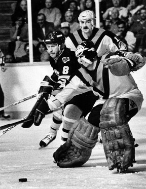Boston’s Jim Nill battles for the puck with Vancouver goaltender John Garrett with Ron Delorme in the background in 1984.