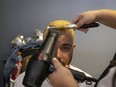 A fan of the Puerto Rico baseball team gets his hair dried after it was bleached as part of a mass hair dying event in an attempt to break the Guinness World Record for the most hair dyed in eight hours in Guaynabo, Puerto Rico, Friday, March 10, 2023. Going blond, which began as a joke among team members playing in California many years ago, was set up by fans to show support for their team competing at the World Baseball Classic.