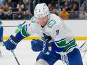 Vancouver Canucks defenceman Jack Rathbone chases down the puck during an Oct. 27, 2022, NHL game in Seattle.