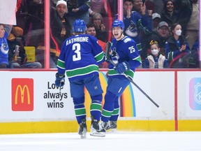 Aidan McDonough #25 of the Vancouver Canucks celebrates after scoring his first NHL goal during the second period of the NHL game against the Calgary Flames at Rogers Arena on March 31, 2023 in Vancouver, British Columbia, Canada.