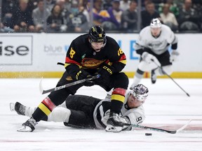 Jack Studnicka battles for the puck with Carl Grundstrom during the first period at Crypto.com Arena on April 10, 2023 in Los Angeles, California.