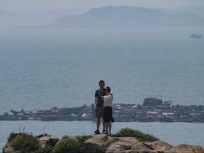 A couple takes a selfie on the coast of Pingtan island, the closest point in China to Taiwan, in southeast China's Fujian province on April 16, 2023.