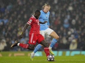 Bayern's Dayot Upamecano, left, fights for the ball with Manchester City's Erling Haaland during the Champions League quarterfinal, first leg, soccer match between Manchester City and Bayern Munich at the Etihad stadium in Manchester, England, Tuesday, April 11, 2023.