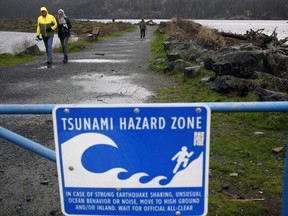 A couple walk along Whiffin Spit Park following a tsunami warning in Sooke, B.C., on Tuesday, January 23, 2018. An earthquake measuring 6 has shaken the seabed a few hundred kilometres off Vancouver Island.The National Tsunami Warning Center in Alaska says a dangerous wave is not expected from the quake.