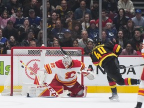 Vancouver Canucks' Elias Pettersson scores a shorthanded goal against Calgary Flames goalie Jacob Markstrom during the first period of an NHL hockey game in Vancouver, on Saturday, April 8, 2023.