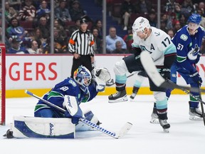 Vancouver Canucks goalie Collin Delia (60) makes the save as Seattle Kraken's Jaden Schwartz (17) and Vancouver's Tyler Myers (57) watch during the second period at Rogers Arena on Tuesday, April 4, 2023.