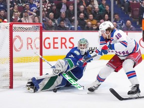 Vancouver Canucks goalie Arturs Silovs, left, stops New York Rangers’ Artemi Panarin on a breakaway during the second period on Feb. 15, 2023.