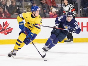 Sweden's Elias Pettersson looks up ice to make a pass as Finland's Lenni Hameenaho gives chase during second period IIHF World Junior Hockey Championship quarter-final hockey action in Moncton, N.B., on Monday, January 2, 2023.