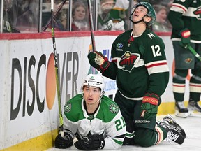 Dallas Stars forward Jason Robertson (left) and Minnesota Wild forward Matt Boldy get tied up along the boards during Game 6 of their opening-round Stanley Cup playoff series on April 28, 2023 in Saint Paul, Minn.