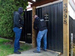 Police were on-hand as government officials went through the former Hells Angels East End clubhouse in Vancouver, BC Friday, April 14, 2023. The BC government seized the house through a civil forfeiture order.
