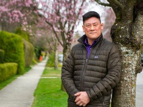 Pastor Ted Ng takes in the blossoms on trees outside his home in Vancouver.