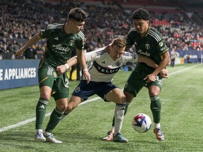 Whitecaps midfielder Julian Gressel gets sandwiched between David Ayala (left) and Evander of the Portland Timbers during their April 8 MLS game at B.C. Place Stadium. After a week off to reflect on their season so far, the Whitecaps take on the Colorado Rapids on Saturday.