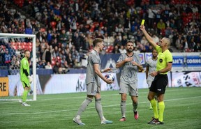 CF Montreal defender Joel Waterman (16) receives a yellow card after holding Vancouver Whitecaps FC defender Ali Ahmed (22) during the first half at BC Place April 1, 2023.