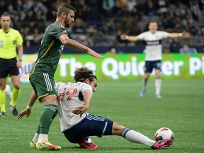 Portland Timbers defender Dario Zuparic (13) challenges Vancouver Whitecaps FC forward Simon Becher (29) during the first half at BC Place Apr 8, 2023.
