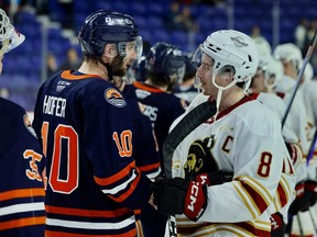 Ryan Hofer (left) and Ty Thorpe shake hands after Hofer's Kamloops Blazers defeated the Vancouver Giants 5-4 in OT on Thursday to win their series 4-0. Photo: Rob Wilton