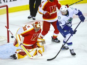 Calgary Wranglers goalie Dustin Wolf battles Abbotsford Canucks Linus Karlsson in second period action.