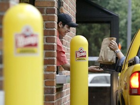 A worker hands a customer a bad of food at a Wendy's drive-thru in Ohio.