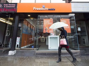 A woman walks past a Freedom Mobile store in Toronto on November 24, 2016.