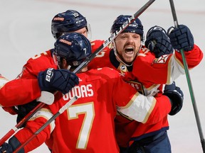 Florida Panthers centre Sam Reinhart (13) celebrates with defenceman Radko Gudas (7) and centre Anton Lundell (15) after scoring the game-winning goal against the Toronto Maple Leafs during overtime in game three of the second round of the 2023 Stanley Cup Playoffs at FLA Live Arena.