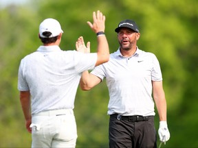 Michael Block, right, of the United States, PGA of America Club Professional, reacts to his hole-in-one on the 15th tee with Rory McIlroy, left, of Northern Ireland during the final round of the 2023 PGA Championship at Oak Hill Country Club on May 21, 2023 in Rochester, N.Y.