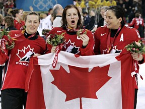 Cassie Campbell (centre), with Jayna Hefford (left) and Vicky Sunohara (right), celebrate after defeating Sweden 4-1 to win the gold medal in womens ice hockey at the 2006 Winter Olympic on Feb. 20, 2006, in Turin.